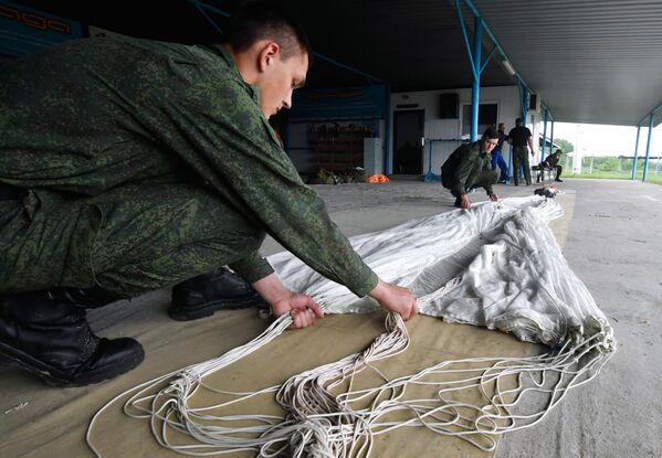Recruits are folding a parachute after accomplishing their first jump at the Enem airfield in the Krasnodar Territory, Russia - Sputnik International