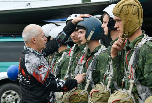 A coach is checking a recruit's equipment before his first jump at the Enem airfield - Sputnik International