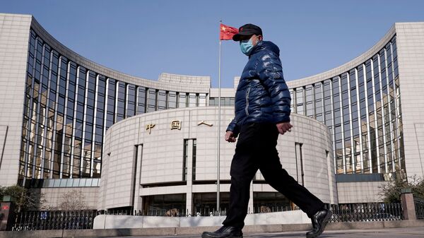 A man wearing a mask walks past the headquarters of the People's Bank of China, the central bank, in Beijing, China, as the country is hit by an outbreak of the new coronavirus, February 3, 2020. - Sputnik International