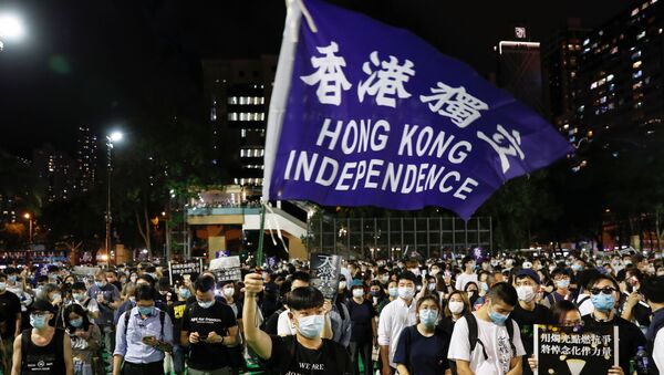 A person wearing a protective face mask waves a Hong Kong independence flag as protesters take part in a candlelight vigil to mark the 31st anniversary of the 1989 protests at Beijing's Tiananmen Square, at Victoria Park, in Hong Kong, China June 4, 2020. - Sputnik International