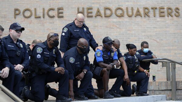 Members of the Austin Police Department kneel in front of demonstrators who gathered in Austin, Texas, Saturday, June 6, 2020, to protest the death of George Floyd, a black man who was in police custody in Minneapolis. Floyd died after being restrained by Minneapolis police officers on Memorial Day. - Sputnik International