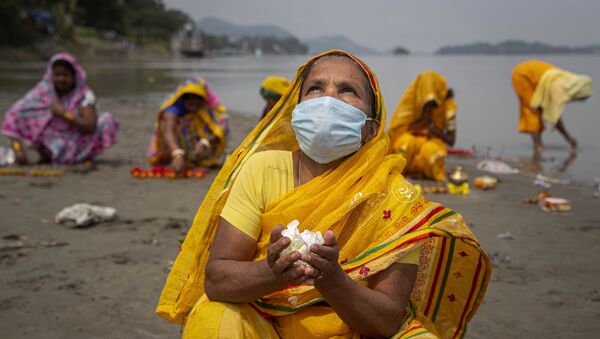 Hindu women perform rituals during a prayer ceremony to rid the world of coronavirus, on the banks of the river Brahmaputra in Gauhati, India, Friday, June 5, 2020 - Sputnik International