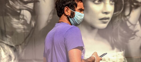 A man uses his mobile phone as he queues to buy alcohol outside a liquor shop after the government eased a nationwide lockdown imposed as a preventive measure against the COVID-19 coronavirus in Gurgaon on May 6, 2020 A man uses his mobile phone as he queues to buy alcohol outside a liquor shop after the government eased a nationwide lockdown imposed as a preventive measure against the COVID-19 coronavirus in Gurgaon on May 6, 2020 - Sputnik International