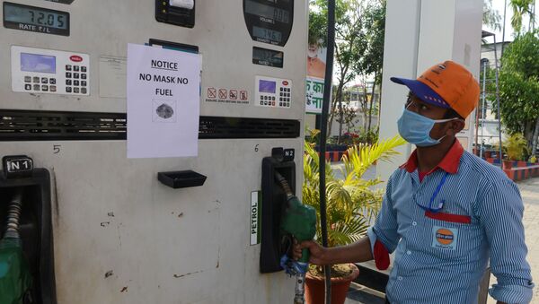 An employee stands near a notice reading 'No Mask No Fuel' at a gas station during a government-imposed nationwide lockdown as a preventive measure against the COVID-19 coronavirus in Siliguri on March 28, 2020. (Photo by Diptendu DUTTA / AFP) - Sputnik International