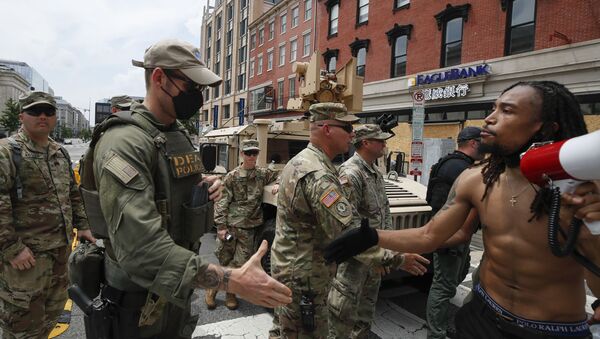 Aaron Covington of St. Louis, greets National Guard soldiers and DEA police as they protest Saturday, June 6, 2020, in Chinatown in Washington, over the death of George Floyd, a black man who was in police custody in Minneapolis. Floyd died after being restrained by Minneapolis police officers. (AP Photo/Alex Brandon) - Sputnik International