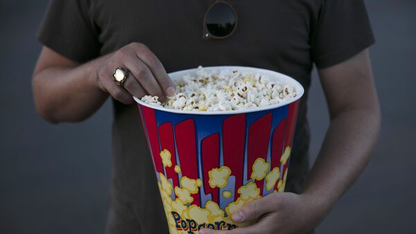 A moviegoer eats popcorn at Mission Tiki drive-in theater in Montclair, Calif., Thursday, May 28, 2020. - Sputnik International