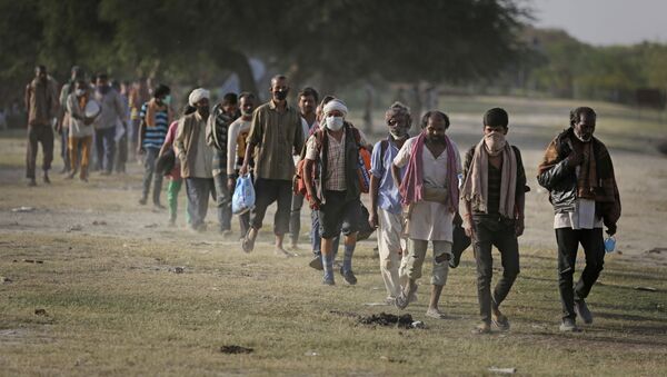 Indian migrant laborers and homeless people walk towards a bus as they are being evicted from the banks of Yamuna River where they have been squatting during lockdown in New Delhi, India, Wednesday, April 15, 2020 - Sputnik International