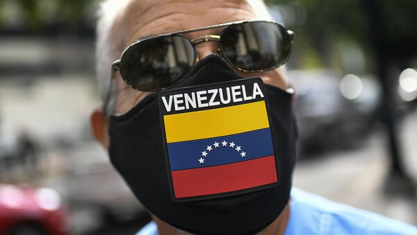 A man wears a face mask with the Venezuela flag, amid the spread of the new coronavirus, as he waits for hours to fill up his car at a state-run oil company PDVSA as station in Caracas, Venezuela, Monday, May 25, 2020 - Sputnik International