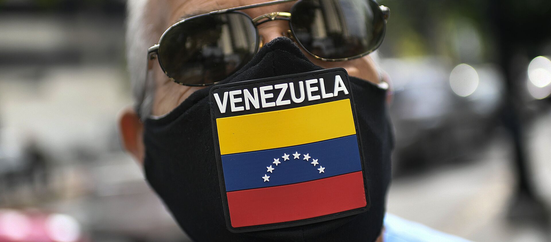 A man wears a face mask with the Venezuela flag, amid the spread of the new coronavirus, as he waits for hours to fill up his car at a state-run oil company PDVSA as station in Caracas, Venezuela, Monday, May 25, 2020 - Sputnik International, 1920, 12.03.2021
