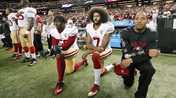 In this Dec. 18, 2016, file photo, San Francisco 49ers quarterback Colin Kaepernick (7) and outside linebacker Eli Harold (58) kneel during the playing of the national anthem before an NFL football game against the Atlanta Falcons in Atlanta - Sputnik International