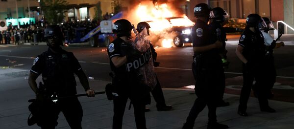 Police officers look on as a car burns in the back as protesters continue to rally against the death in Minneapolis police custody of George Floyd, near the White House, in Washington, U.S., May 30, 2020. Police officers look on as a car burns in the back as protesters continue to rally against the death in Minneapolis police custody of George Floyd, near the White House, in Washington, U.S., May 30, 2020. - Sputnik International