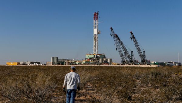  An oil worker walks towards a drill rig after placing ground monitoring equipment in the vicinity of the underground horizontal drill in Loving County, Texas, U.S., November 22, 2019. Picture taken November 22, 2019 - Sputnik International