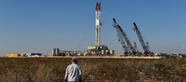  An oil worker walks towards a drill rig after placing ground monitoring equipment in the vicinity of the underground horizontal drill in Loving County, Texas, U.S., November 22, 2019. Picture taken November 22, 2019 - Sputnik International