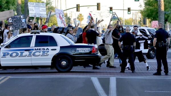 Protesters demanding police reform walk past Mesa police officers blocking a street, Tuesday, June 9, 2020, in Mesa, Ariz. The protest is a result of the death of George Floyd, a black man who died after being restrained by Minneapolis police officers on May 25 - Sputnik International