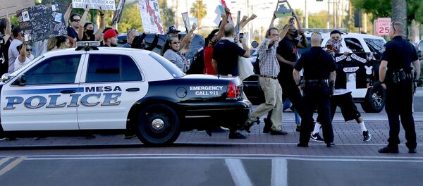 Protesters demanding police reform walk past Mesa police officers blocking a street, Tuesday, June 9, 2020, in Mesa, Ariz. The protest is a result of the death of George Floyd, a black man who died after being restrained by Minneapolis police officers on May 25 - Sputnik International