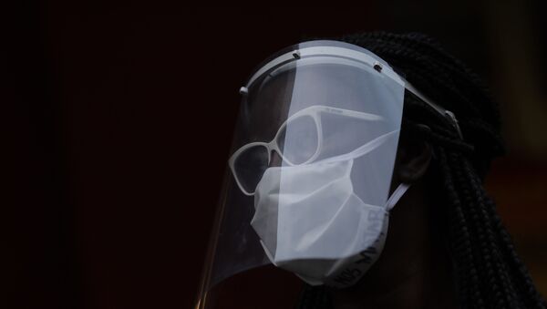 A woman wearing a face mask and shield to protect herself from the spread of the new coronavirus, takes part in a protest against racism and police violence during a Black Lives Matter demonstration amid in Duque de Caxias, Brazil, Wednesday, June 10, 2020. - Sputnik International