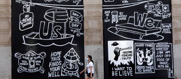 A woman wearing a protective face mask walks past graffiti on boarded up and closed storefronts in the Soho neighborhood of Manhattan during the outbreak of the coronavirus disease (COVID-19) in New York City, New York, U.S., May 26, 2020. - Sputnik International