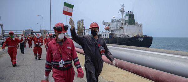A worker of the Venezuelan state oil company PDVSA waves an Iranian flag as the Iranian-flagged oil tanker Fortune docks at the El Palito refinery in Puerto Cabello, in the northern state of Carabobo, Venezuela, on May 25, 2020 - Sputnik International