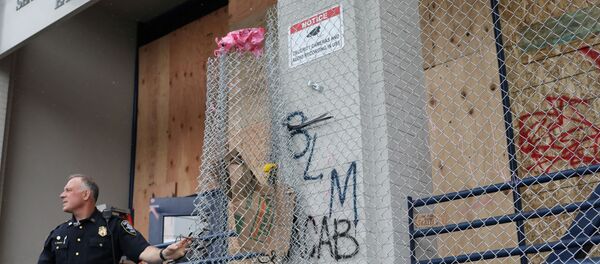 A police officer stands as he removes a wire barricade at the entrance of Seattle Police Department East Precinct in Seattle, Washington, U.S. June 11, 2020. - Sputnik International