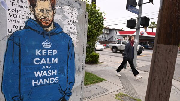 People walk past graffiti of Prince Harry wearing a hoodie reading Keep Calm and Wash Your Hands, on 7 April 2020, during the coronavirus pandemic in Los Angeles, California. - Sputnik International