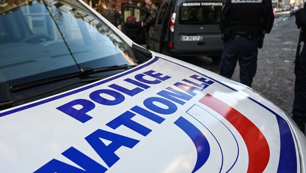 In this file photo taken on 3 December 2019, a French police officer stands next to a French Police Nationale car in Lille, northern France. - Sputnik International
