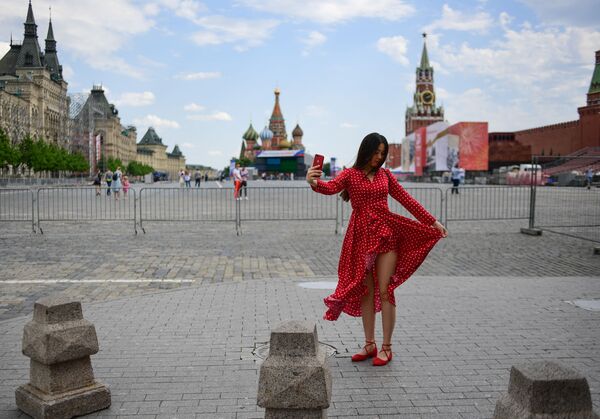 A woman poses for a selfie at Red Square on a sunny day amid the coronavirus outbreak, in Moscow, Russia. - Sputnik International