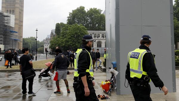 Police officers walk past a boarded-up statue of British wartime Prime Minister Winston Churchill on Parliament square in central London on June 12, 2020. - Sputnik International
