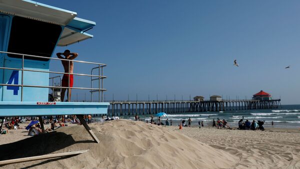 A lifeguard stretches while watching the water from a tower at the beach on Memorial Day weekend during the outbreak of the coronavirus disease (COVID-19) in Huntington Beach, California, U.S., May 23, 2020. REUTERS/Patrick T. Fallon - Sputnik International