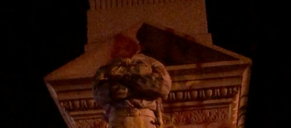 A protester walks past Confederate statues without their heads and covered in grafitti, in this still picture obtained from social media video dated June 10, 2020 in Portsmouth, Virginia A protester walks past Confederate statues without their heads and covered in grafitti, in this still picture obtained from social media video dated June 10, 2020 in Portsmouth, Virginia - Sputnik International