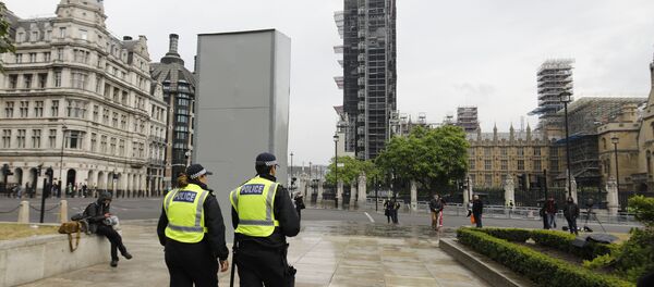Police officers walk past a boarded-up statue of British wartime Prime Minister Winston Churchill on Parliament square in central London on June 12, 2020 - Sputnik International