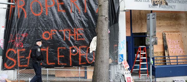 A police officer walks in front of Seattle Police Department East Precinct in Seattle, Washington, U.S. June 11, 2020. - Sputnik International