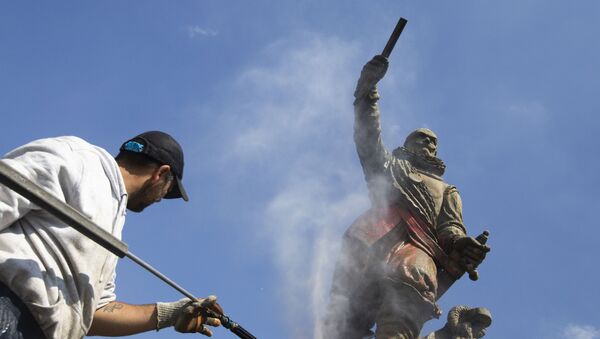 A municipal worker used a high pressure water cleaner to remove the paint from the statue of Piet Hein in Rotterdam, Netherlands, Friday, June 12, 2020. Dutch activists have spray painted the words killer and thief and daubed red paint on a statue of a man regarded by many as a naval hero from the 17th-century Golden Era of Dutch trade and colonial expansion. (AP Photo/Peter Dejong) - Sputnik International