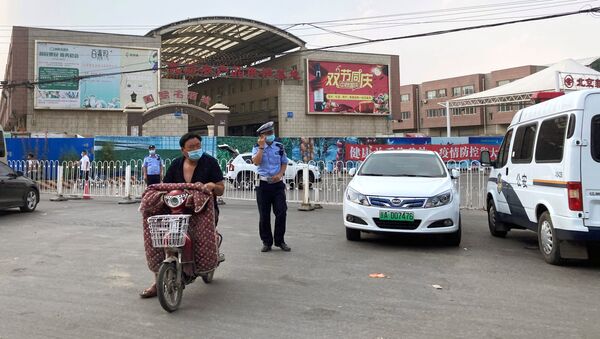 Police officers wearing face masks are seen outside the Xinfadi wholesale market, which has been closed for business after new coronavirus infections were detected, in Beijing, China June 13, 2020. - Sputnik International