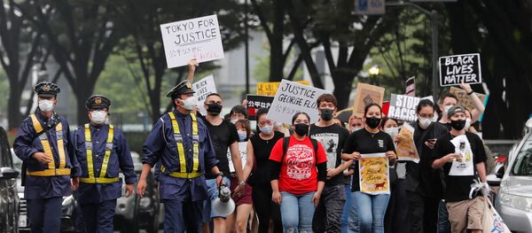 People wearing face masks march during a Black Lives Matter protest following the death in Minneapolis police custody of George Floyd, in Tokyo, Japan June 14, 2020 - Sputnik International