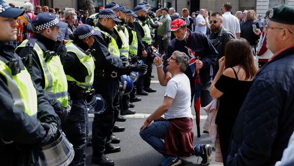 A demonstrator gestures as he kneels in front of the police officers during BLM protest in London - Sputnik International