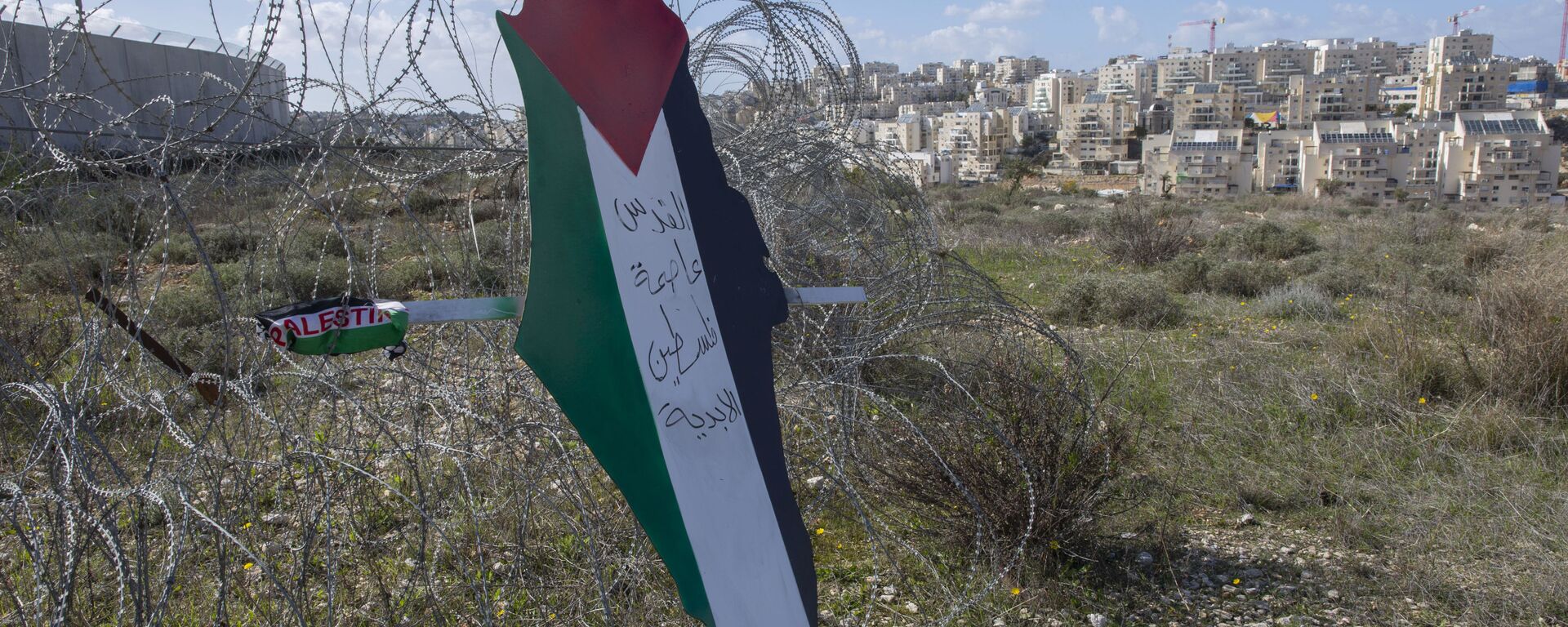 Placard with the colors of the Palestinian flags at a barbed wire - Sputnik International, 1920, 13.02.2023