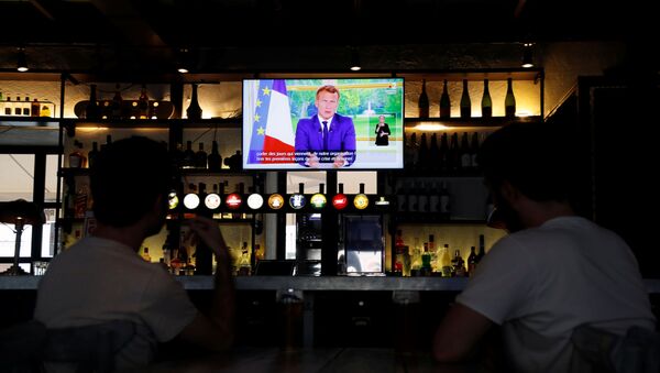 French President Emmanuel Macron is seen on a television screen in a pub while he addresses the nation - Sputnik International