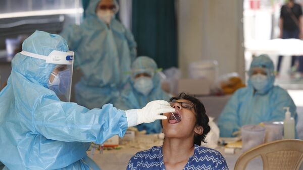 A health worker takes a swab test at a COVID-19 testing center in New Delhi, India, Monday, April 27, 2020. India’s main medical research organization has cancelled orders to procure rapid antibody test kits from two Chinese companies after quality issues and controversies over its price.  - Sputnik International