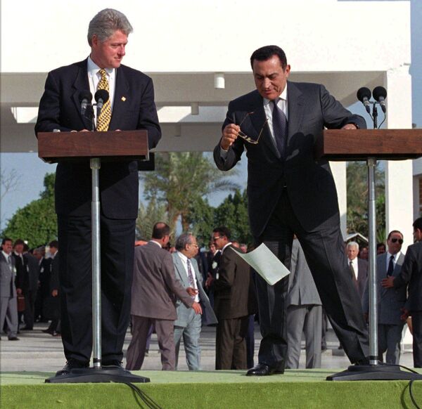 US President Bill Clinton looks on as his Egyptian counterpart Hosni Mubarak's papers are carried away by a gust of wind during the final address following their one-day Summit of Peacemakers in Sharm El Sheik, Wednesday March 13, 1996 - Sputnik International