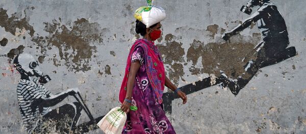 A woman wearing a protective face mask walks past a graffiti, after authorities eased lockdown restrictions that were imposed to slow the spread of the coronavirus disease (COVID-19), in Mumbai, India, June 12, 2020 A woman wearing a protective face mask walks past a graffiti, after authorities eased lockdown restrictions that were imposed to slow the spread of the coronavirus disease (COVID-19), in Mumbai, India, June 12, 2020 - Sputnik International