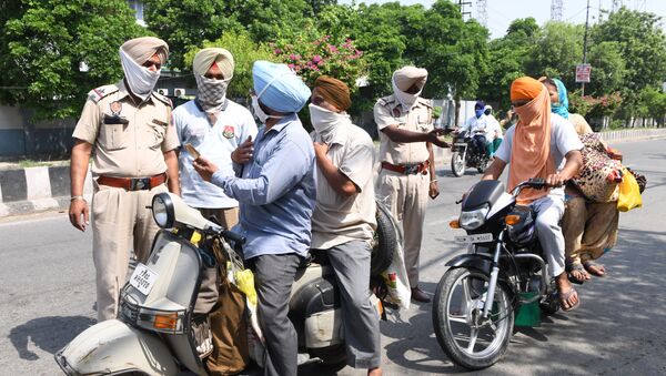 Police personnel check commuters after strict lockdown norms for weekends and public holidays were imposed as a preventive measure against the COVID-19 coronavirus, in Amritsar on June 14, 2020 - Sputnik International