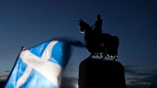 A Scottish Saltire flag blows in the wind near the statue of Scottish King Robert the Bruce, at Bannockburn, Scotland, Thursday, Jan. 12, 2012 - Sputnik International
