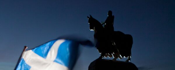 A Scottish Saltire flag blows in the wind near the statue of Scottish King Robert the Bruce, at Bannockburn, Scotland, Thursday, Jan. 12, 2012 - Sputnik International