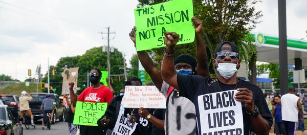 In this file photo taken on June 14, 2020 People hold signs toward traffic outside a burned Wendy’s restaurant on the second day following the police shooting death of Rayshard Brooks in the restaurant parking lot, in Atlanta, Georgia. - Sputnik International