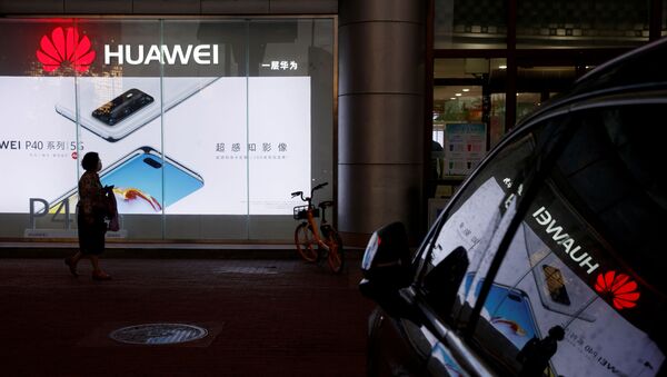 A woman walks past a Huawei store in Beijing, China May 28, 2020 - Sputnik International