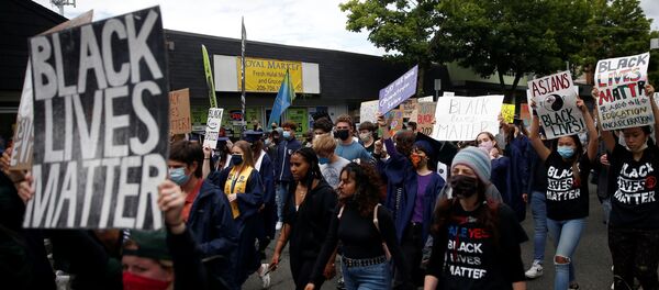 Demonstrators march up Lake City Way NE as Nathan Hale High School seniors join with others to protest against racial inequality in the aftermath of the death in Minneapolis police custody of George Floyd on their graduation day in Seattle, Washington, U.S. June 15, 2020 - Sputnik International