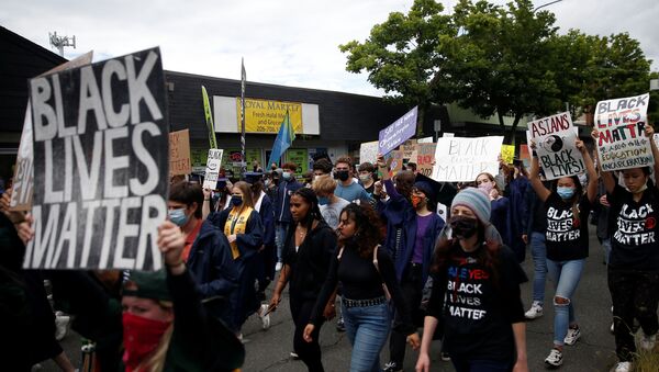 Demonstrators march up Lake City Way NE as Nathan Hale High School seniors join with others to protest against racial inequality in the aftermath of the death in Minneapolis police custody of George Floyd on their graduation day in Seattle, Washington, U.S. June 15, 2020 - Sputnik International