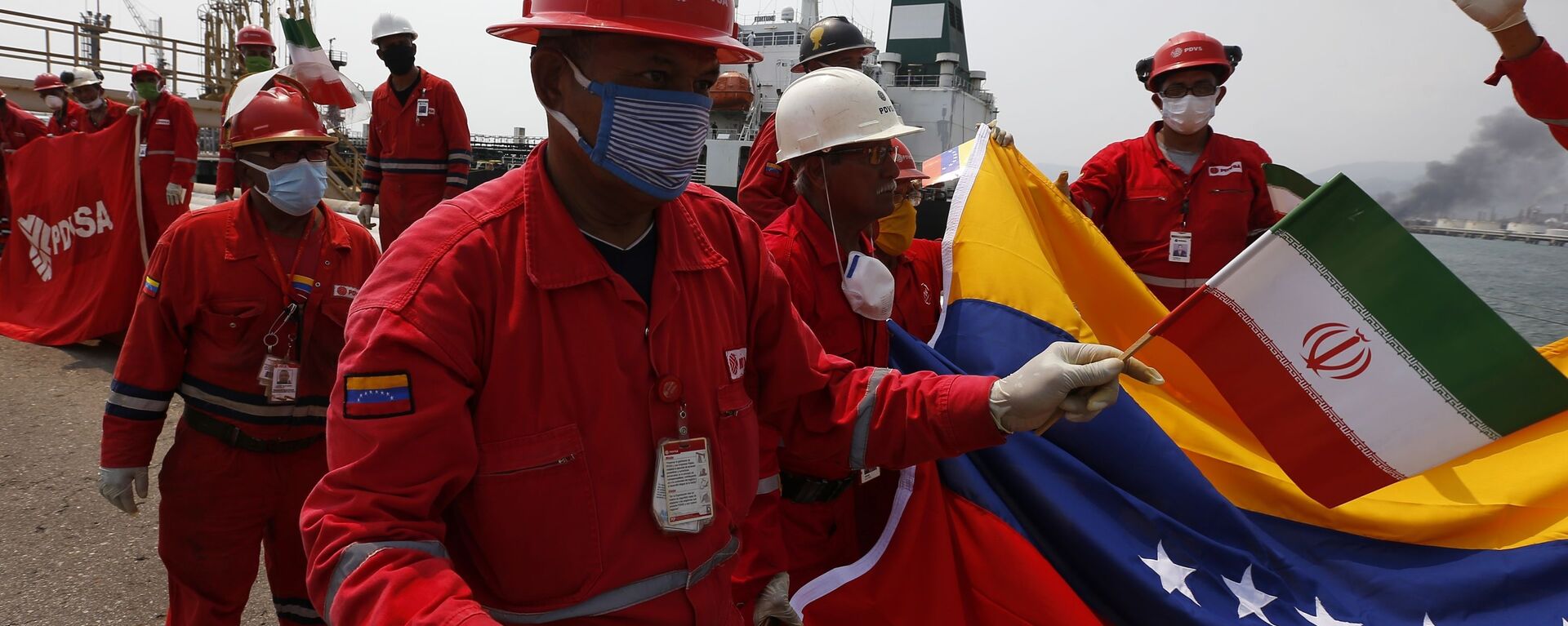A Venezuelan oil worker holding a small Iranian flag attends a ceremony for the arrival of Iranian oil tanker Fortune at the El Palito refinery near Puerto Cabello, Venezuela, Monday, May 25, 2020 - Sputnik International, 1920, 05.10.2022