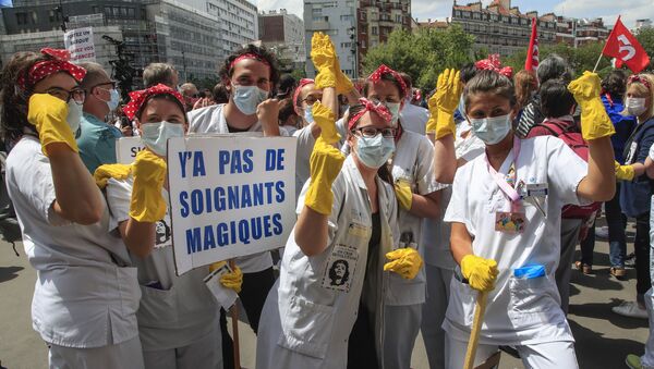 Medical personnel from the Robert Debre hospital wear masks to help curb the spread of the coronavirus holding a placard that reads, 'there are no magic medics' as they stage a protest in Paris, Thursday, June 11, 2020 - Sputnik International