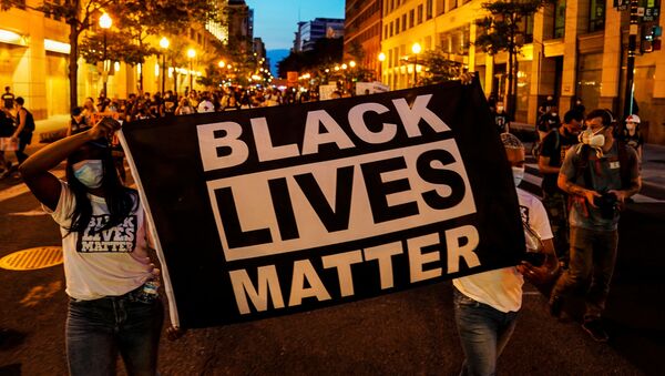 People hold up a Black Lives Matter banner as they march during a demonstration against racial inequality in the aftermath of the death in Minneapolis police custody of George Floyd, in Washington, U.S., June 14, 2020 - Sputnik International